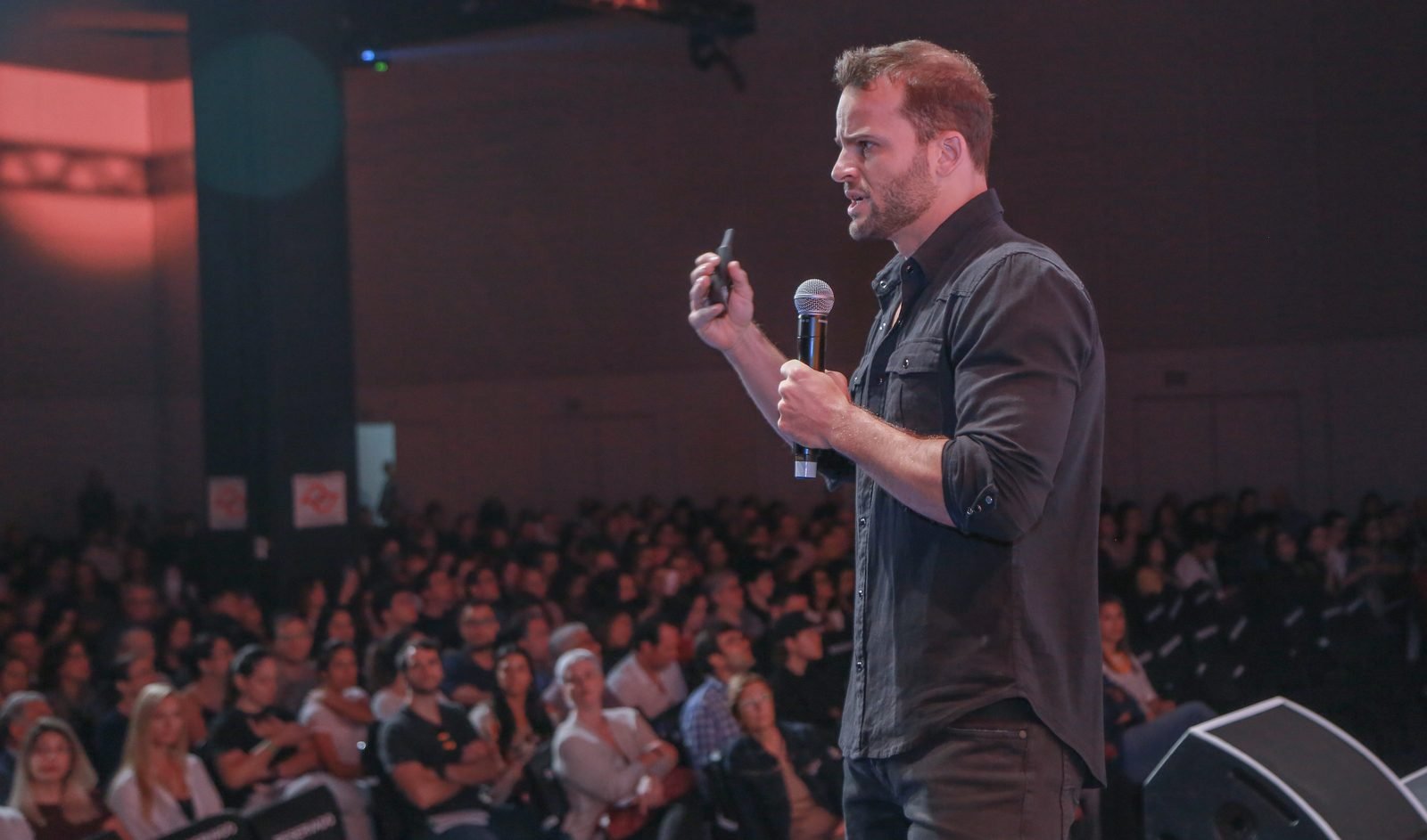 Rafa Lund palestrando no palco da Tribo Forte para uma plateia lotada